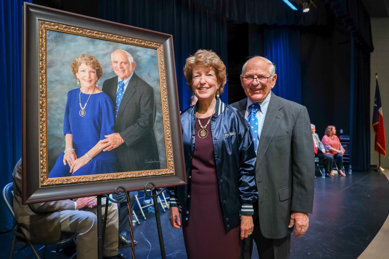 Bill and Cindy Haskett pose with their official portrait to be displayed at the junior high school named in their honor.